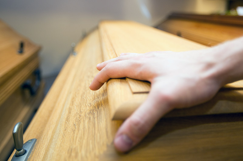 Hand auf Sarg